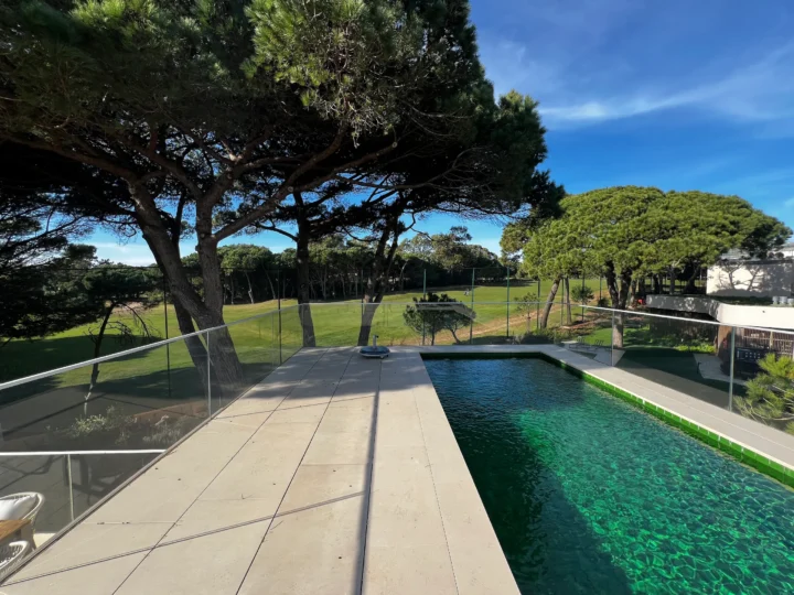 Luxury villa with private pool and glass railing overlooking a golf course in Quinta da Marinha.