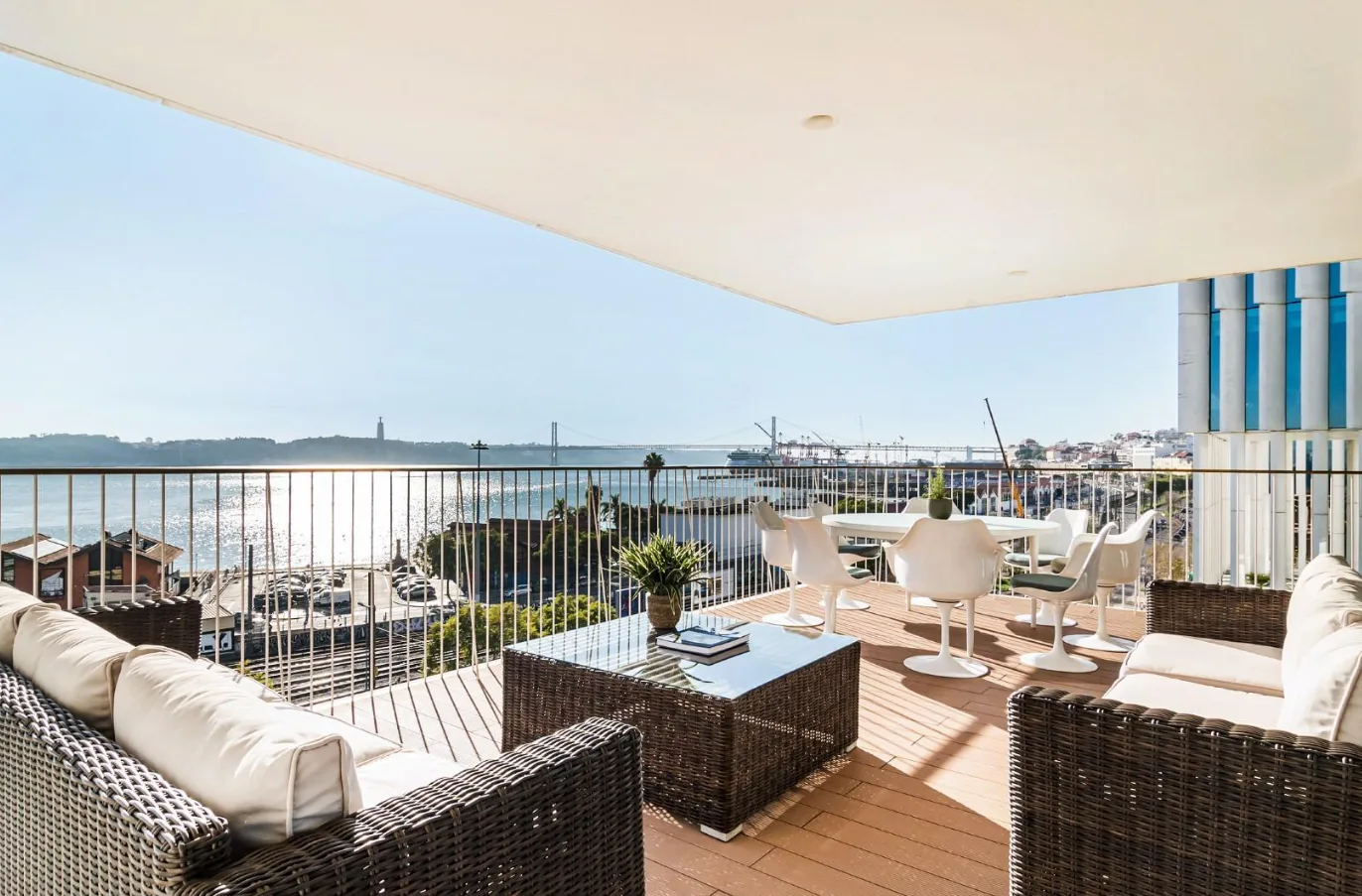 Luxury penthouse balcony in Santos, Lisbon, with river and bridge views.